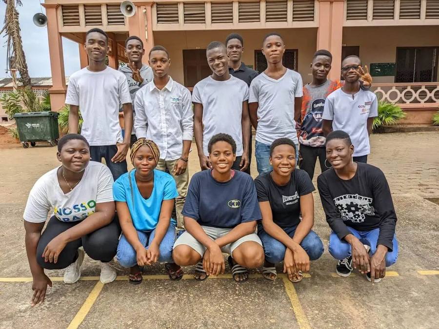 Une équipe mixte d'une quinzaine de jeunes pose en deux rangs devant un bâtiment