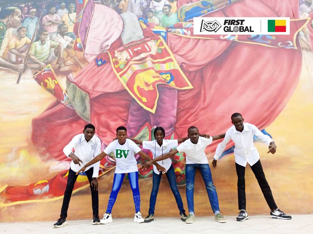 La Team Benin 2026, cinq jeunes en tenue blanche, pose de façon dynamique devant une grande fresque historique colorée